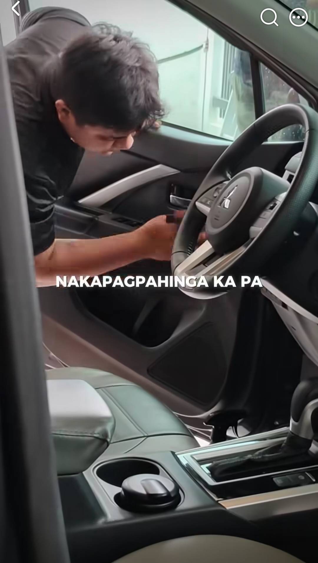 Thunder Auto Hub technician detailing a car interior, cleaning around the Mitsubishi steering wheel and center console